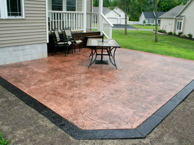 Stamped concrete patio with dark brown edging.