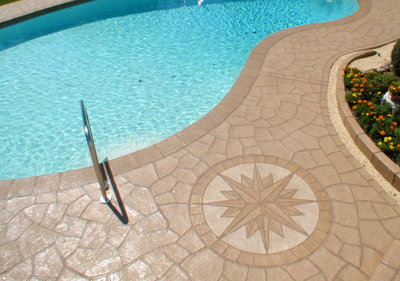 Stamped concrete pool deck with compass design detail.
